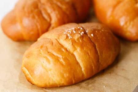 Close up plate of Shio Pan, Japanese salted butter rolls on brown baking paper.の写真素材