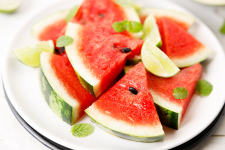 Grilled watermelon with lime and mint leaves. Sliced watermelon salad with lime juice. Summer dish. Closeup.の写真素材