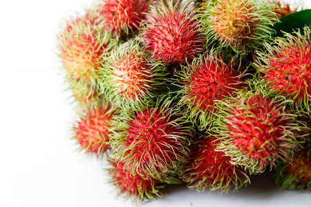 Bunch of Fresh rambutan fruit, an exotic sweet fruit from southeast Asia, on wooden table.の写真素材