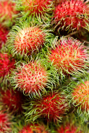 Bunch of Fresh rambutan fruit, an exotic sweet fruit from southeast Asia, on wooden table.の写真素材