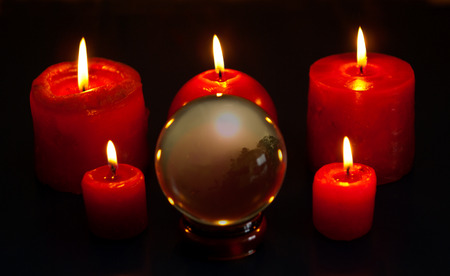 Crystal ball and five red candles burningの写真素材