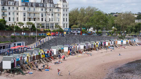 Torquay, United Kingdom - June 21, 2015: Families enjoy a day at the beach huts on Torquay Beach, Englandのeditorial素材