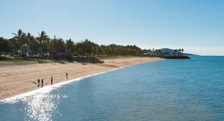 Children fishing and families enjoying a warm winter day at the beach at Townsville, Australia