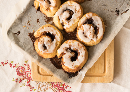 Cinnamon scrolls with icing on baking tray