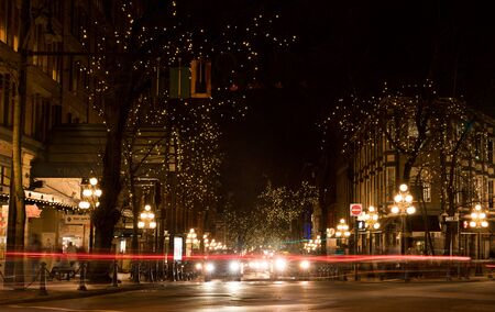 Vancouver, Canada - January 28, 2017: Gastown, Vancouver at night with lights in the trees and light trails from the traffic.のeditorial素材