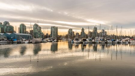 Vancouver city skyline with boats in harbour at sunsetの写真素材