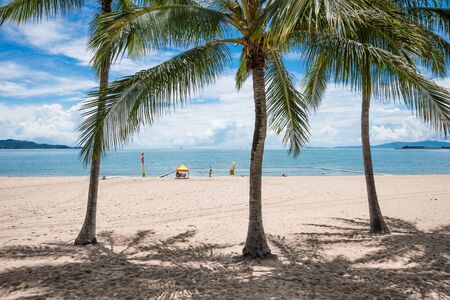People enjoying a swim on tropical beach, The Strand, Townsville, Australia while a lifeguard keeps watchの写真素材