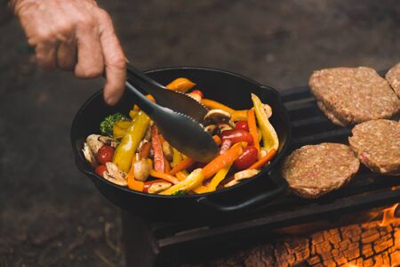 Hamburgers and vegetables cooking on a barbecueの写真素材