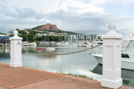 Boats in Townsville Marina with Castle Hill in background, focus on bollardsの写真素材