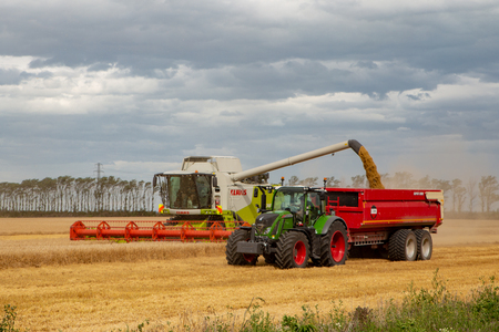 Dorie, Canterbury, New Zealand - January 19 2019: A combine harvester unloads barley into the bins in a field in summertimeのeditorial素材