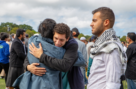 Christchurch, Canterbury, New Zealand, March 22 2019: Muslim men greet each other at the prayer service in Hagley Park one week after the mosque shootingsのeditorial素材