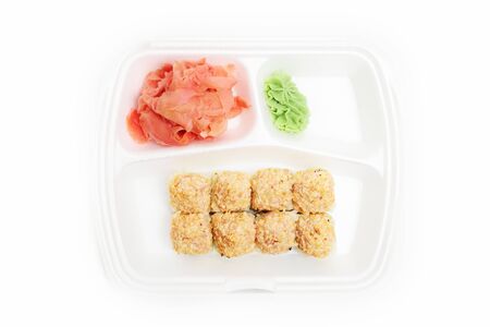 Japanese rolls in a restaurant with fish and vegetables in container box isolated on white backgroundの写真素材