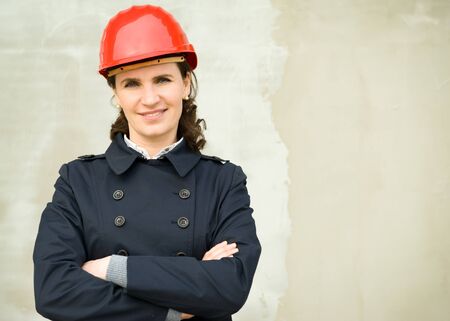 Portrait of business woman wearing protection helm against the new wallの写真素材