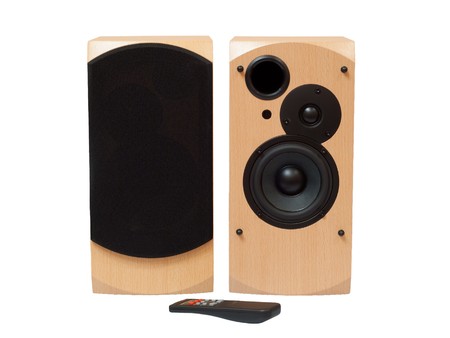 wooden acoustic system with black speakers and remote control isolated on white backgroundの写真素材