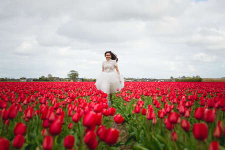 Lisse/Netherlands - 20/04/2019: Young woman is walking through the flower fields in Hollandのeditorial素材