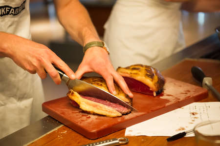 Amsterdam/Netherlands - 25/07/2019: Roasted meat is being cut for serving. Cooking class in Amsterdam.のeditorial素材