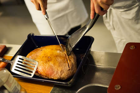 Amsterdam/Netherlands - 25/07/2019: Roasted meat is being cut for serving. Cooking class in Amsterdam.のeditorial素材