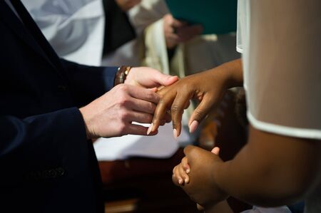 White skin man and black skin woman are getting married in a churchの写真素材