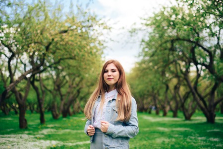 Beautiful woman in a summer park in sunny weatherの写真素材