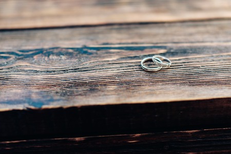 Two wedding rings on a wooden background 1