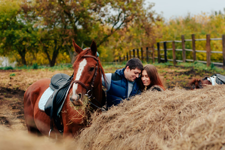 young couple in a Russian village with horses, riding 1の写真素材