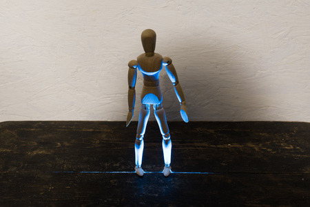 wooden man on black background with backlight from belowの写真素材