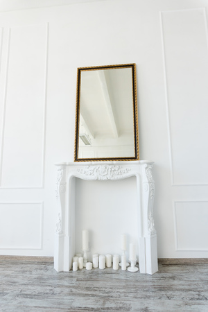 white fireplace with a mirror above it in an empty roomの写真素材