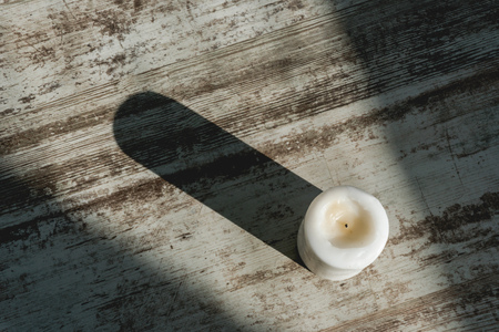 round white candle without a fire on a gray-brown backgroundの写真素材