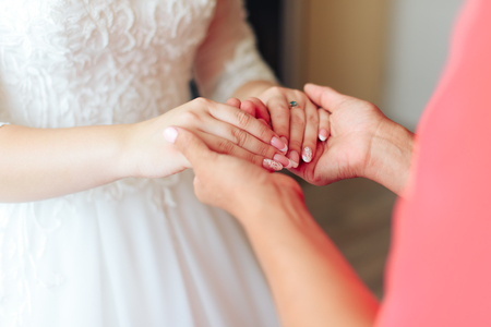 morning of the bride, a beautiful woman in a white dress is preparing for the weddingの写真素材