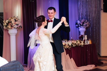 the newlyweds are dancing in the banquet hall at the weddingの写真素材