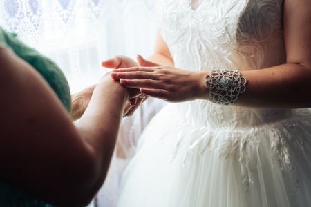 morning of the bride, a beautiful woman in a white dress is preparing for the wedding 1の写真素材