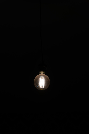 retro incandescent lamp on a black backgroundの写真素材