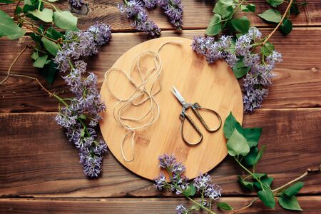 scissors and lilac on wooden background top viewの写真素材