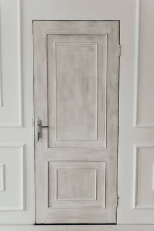 gray door on white wall background with keys in the lock