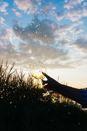 a glass of water on the background of the river and the sunsetの写真素材