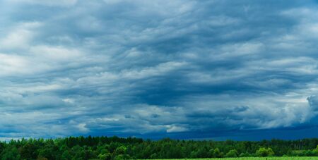 green field with skyline and dark stormy skyの写真素材