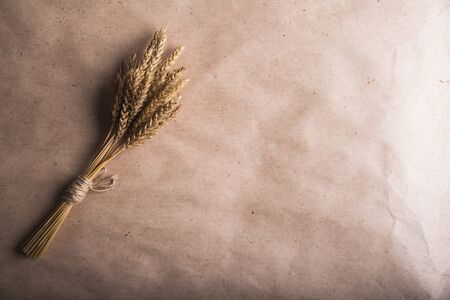bunch of wheat ears on the background of Kraft paperの写真素材