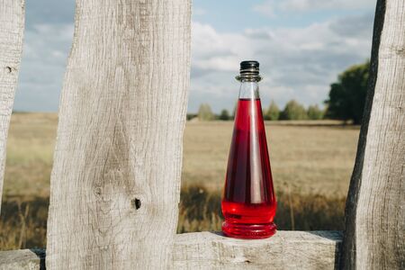 bottle with refreshing red lemonade in backlight outdoorsの写真素材