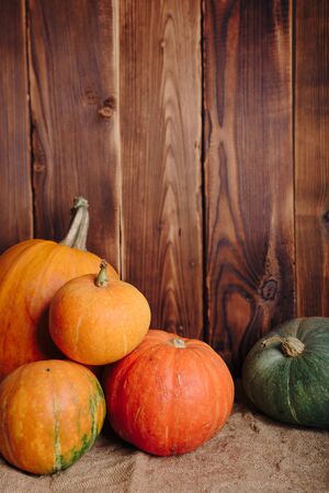 autumn set of pumpkins and dried leaves on a wooden backgroundの写真素材