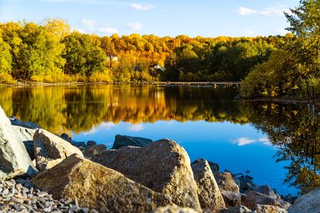 autumn landscape with blue sky and a small lake