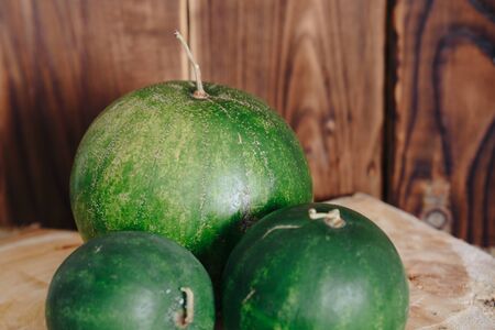 several mini watermelons on a wooden backgroundの写真素材