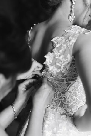 preparing the bride for the wedding in a wedding dressの写真素材