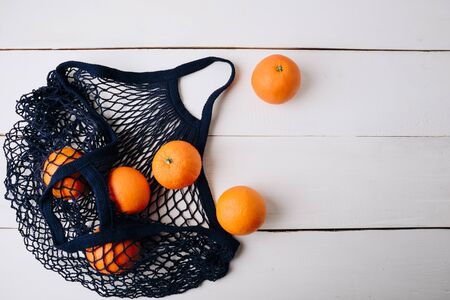 eco- friendly bag string bag with oranges on a wooden backgroundの写真素材