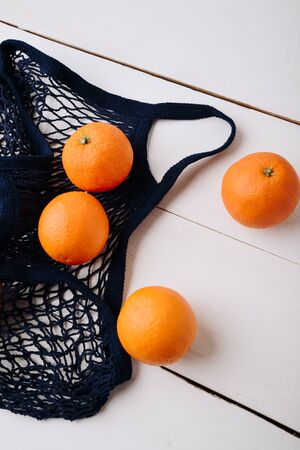 eco- friendly bag string bag with oranges on a wooden backgroundの写真素材