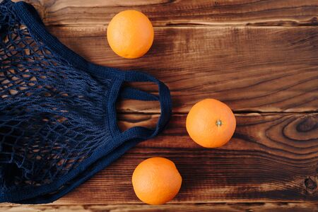 eco- friendly bag string bag with oranges on a wooden backgroundの写真素材