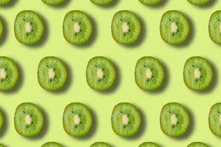 summer pattern with green juicy ripe fresh kiwi on a green backgroundの写真素材