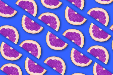 summer pattern with juicy ripe fresh slices of purple grapefruit on a blue background