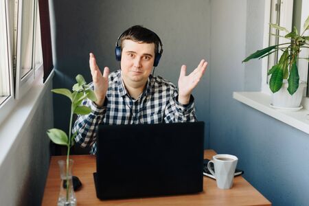 a man works from home sitting at a table with a laptopの写真素材