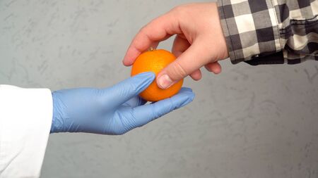 woman doctor offering an orange to boost immunity 1