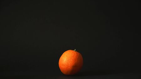 Fresh single orange on a black backgroundの写真素材